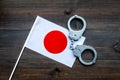 Violation of law, law-breaking concept. Metal handcuffs on Japaniese flag on dark wooden background top view