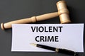VIOLENT CRIME - words on white paper on dark background with judge\'s gavel Royalty Free Stock Photo