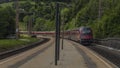 Violet Austria train in Klamm station near Semmering pass in summer cloudy day