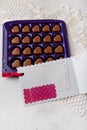 Violet box of heart shaped chocolates, blank postcard on white lace background. Valentines day 14 February sweet present Royalty Free Stock Photo