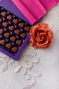 Violet box of heart shaped chocolates, lace and fabric rose flower on white background. Valentines day 14 February sweet present Royalty Free Stock Photo