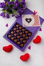 Violet box of heart shaped chocolates, postcard, red toys and flowers on white background. Valentines day 14 February sweet Royalty Free Stock Photo