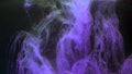 Violet color paint ink diffuses in water in slow motion on black background with inky cloud swirling and abstract smoke