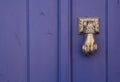 Violet door with a knocker hand Royalty Free Stock Photo