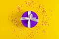 A violet gift box on yellow background