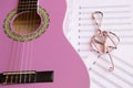 Violet guitar for children with treble clef on music sheets back