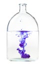Violet ink dissolves in water in bottle isolated Royalty Free Stock Photo