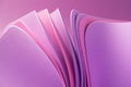 Violet pastel wavy paper sheets on a purple background.