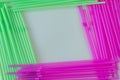 Violet pink and green drinking straws in frame