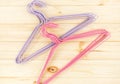 Violet and pink hangers for clothes on beige wooden background. Empty cloth hanger template. Fashion blog, sales, store,