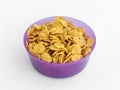 Violet plastic round medium size bowl for loose products filled with cornflakes isolated on a white background Royalty Free Stock Photo