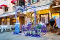 Violet purple vibrant heart shape arc, bicycle and bench decoration at the entrance to the lavender shop in the center of Sirmione