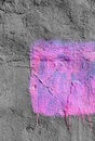 Violet square with peeling paint on gray plastered wall background. Grunge texture. copy space