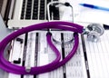 Violet stethoscope on a laptop computer