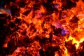 Violet tongues of flame from burning non-ferrous metals break through the hot coal. Royalty Free Stock Photo