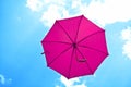 Violet umbrella flying on blue sky