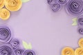 Violet and yellow paper craft rose flower flat lay background with flowers and leaves on around the border Royalty Free Stock Photo