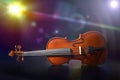 Violin on black wooden table on stage with colorful lights