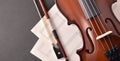 Violin body and bow with sheet music on black table Royalty Free Stock Photo