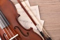 Violin body and bow with sheet music on wood table Royalty Free Stock Photo