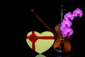Violin with bow, heart shape gift box and pink orchids on dark background Royalty Free Stock Photo