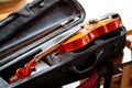 Violin with a bow laying in an open black fiddle case on the table. Classical musical string instruments group concept, nobody