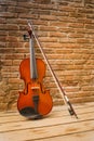 Violin and bow lean against the old brick wall Royalty Free Stock Photo