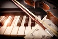 Violin bow and sheet music on piano keys front view Royalty Free Stock Photo