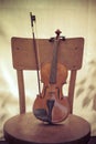 violin and bow, stand on an old wooden chair. Concept art. Vintage style toned photo Royalty Free Stock Photo