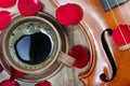 Violin and a cup of coffee. Coffee and rose petals. Top view. close up. Royalty Free Stock Photo