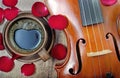 Violin and a cup of coffee. Coffee and rose petals. Top view. close up. Royalty Free Stock Photo