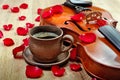 Violin and a cup of coffee. Coffee and rose petals. Royalty Free Stock Photo