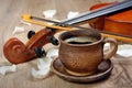 Violin and a cup of coffee. Coffee and rose petals. Royalty Free Stock Photo