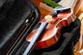 Violin, fiddle with a bow laying in an open black case on the table, small xylophone in the back. Simple classical musical string
