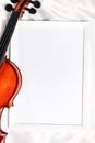 Violin or fiddle lying on the white silk background. String instrument.