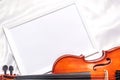 Violin or fiddle lying on the white silk background. String instrument.