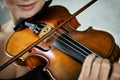 Violin and a fiddlestick in hands of a young female violinist