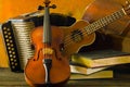 Violin, guitar and books on still-life wooden background Royalty Free Stock Photo