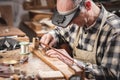 Violin maker inside a rustic workshop is working on a bow with precision Royalty Free Stock Photo