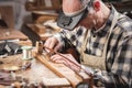 Violin maker inside a rustic workshop is working on a bow with precision