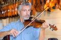 Violin maker while testing violins in laboratory