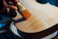 Violin maker varnishing a violin body close up.