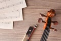 Violin pegbox and bow with sheet music on wood table