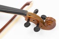 Violin Scroll with Tuning Pegs and Fiddle Bow in the background Royalty Free Stock Photo