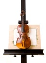 Violin standing on painting easel isolated Royalty Free Stock Photo