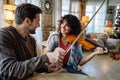 Violin teacher helping a woman student at home Royalty Free Stock Photo