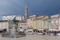 Violinist Giuseppe Tartini statue in Tartini Square Piran Slovenia with St George`s Parish church and bell clock tower in Piran