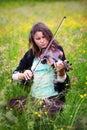 Violinist on a meadow full of flowers Royalty Free Stock Photo