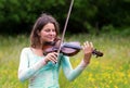 Violinist on a meadow full of flowers Royalty Free Stock Photo