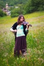 Violinist on a meadow full of flowers Royalty Free Stock Photo